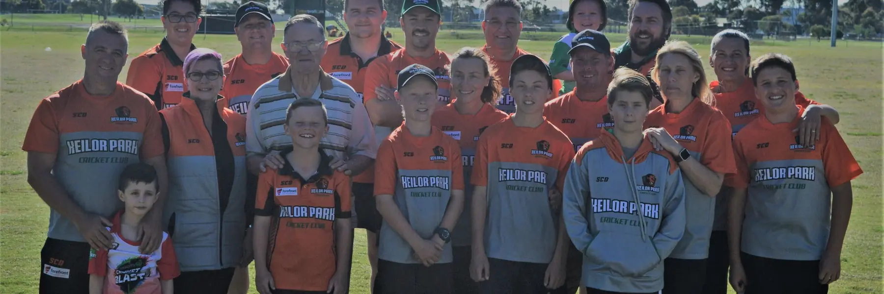 Keilor Park players, juniors and families together in orange club shirts